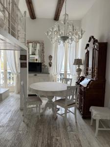 a dining room with a table and chairs and a chandelier at Maison Menton in Menton