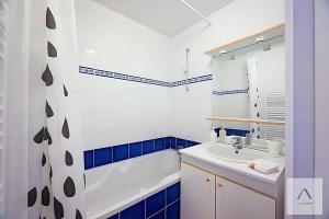 a bathroom with a white sink and blue tiles at Le Prieuré in Dinard