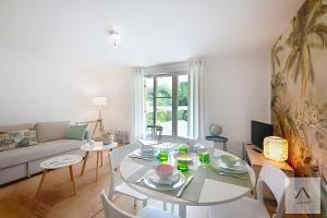 a living room with a table and a couch at Le Prieuré in Dinard