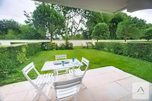 a white table and chairs in a garden at Le Prieuré in Dinard