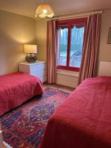 a bedroom with two beds and a window at La Forge de Paul et Virginie in Mainneville