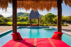 una piscina del complejo con una silla y un cenador en Hotel Punta Teonoste, en Popoyo
