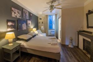 a bedroom with a large bed and a fireplace at La Maison aux Puits in Cordes-sur-Ciel