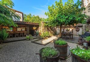 a courtyard with a table and chairs and trees at La Maison aux Puits in Cordes-sur-Ciel
