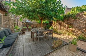 a patio with a blue couch and a table and chairs at La Maison aux Puits in Cordes-sur-Ciel +9 photos