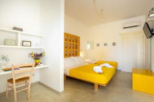 a bedroom with a yellow bed and a table at TerreAmare Agriturismo in Porto Cesareo