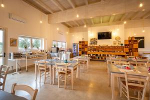 a restaurant with tables and chairs and a kitchen at TerreAmare Agriturismo in Porto Cesareo