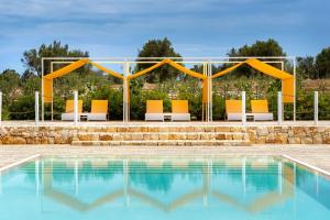 a group of chairs sitting next to a swimming pool at TerreAmare Agriturismo in Porto Cesareo +34 photos