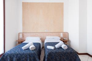 Dos camas en una habitación con toallas. en Regina Hotel e Ristorante, en Punta Marina