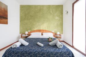 una camera da letto con letto blu e cuscini bianchi di Regina Hotel e Ristorante a Punta Marina