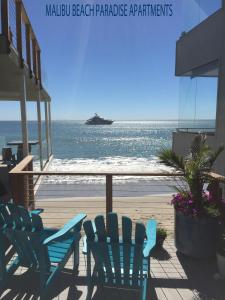 - un ensemble de chaises bleues assises sur un balcon donnant sur l'océan dans l'établissement Malibu Private Beach Apartments, à Malibu