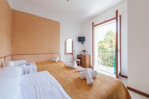 a bedroom with two beds and a large window at Regina Hotel e Ristorante in Punta Marina