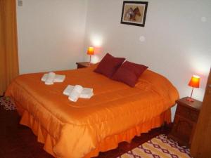 Un dormitorio con una cama con dos toallas encima. en Hosteria Renca, en Renca