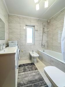a bathroom with a tub and a toilet and a sink at KaVacottage in Krivorovnya +7 photos