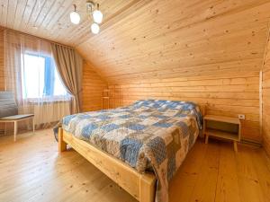 a bedroom with a bed in a wooden room at KaVacottage in Krivorovnya