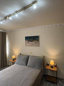 ein Schlafzimmer mit einem Bett, zwei Nachttischen und zwei Lampen in der Unterkunft Aphrodite View in Korakiaí