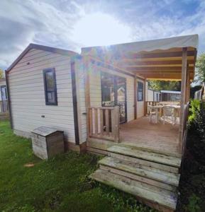 a small house with a porch and a deck at Camping Vauban in Bergues +6 photos