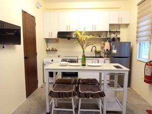 a kitchen with a white island with two stools at Viajeros Apartelle in Valencia