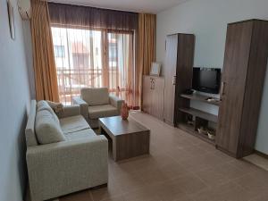 a living room with a couch and a tv at Апартаменти Литорал in Chernomorets