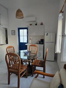 a kitchen with a glass table and chairs and a dining room at Kapsali Beach House in Kapsali