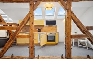 an attic kitchen with yellow cabinets and a stove at Gut Barzig in Großräschen
