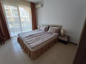 a bedroom with a bed and a large window at Апартаменти Литорал in Chernomorets +20 photos