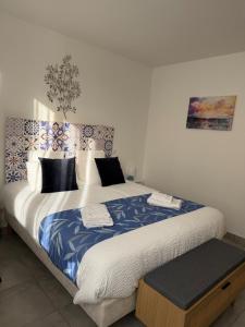 a bedroom with a large bed with blue and white sheets at La Belle Prise in Matougues
