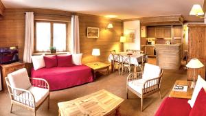 a living room with a red bed and a table at Chalet Les Alpes in Val-d'Isère