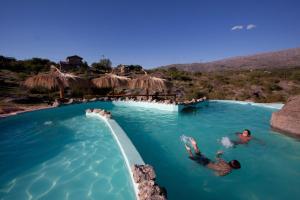 two people swimming in a pool at a water park at Aldea Serrana in Nono