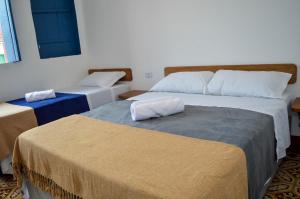 two beds in a room with two bedsitures at Casarão Duque do Mel in João Pessoa