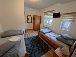 ein kleines Zimmer mit zwei Betten und einem Fernseher in der Unterkunft Osada Chybotek in Preseka