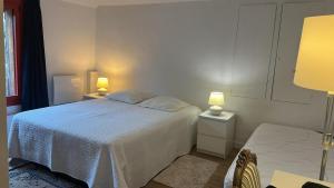 a white bedroom with a bed and two lamps at La Forge de Paul et Virginie in Mainneville +7 photos