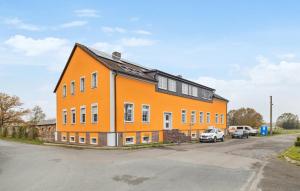 an orange building with cars parked in a parking lot at Gut Barzig in Großräschen