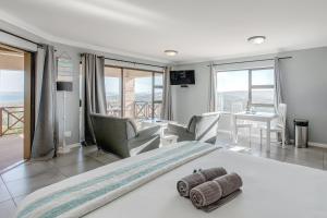 a bedroom with a bed and a living room at Garden Route Ilita Lodge in Great Brak River