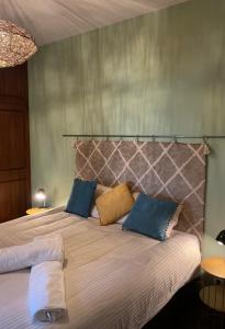 a bedroom with a large bed with blue and yellow pillows at Casa Žerotín in Funchal