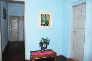 a room with blue walls and a table with a vase at Hotel Paulista in São Vicente