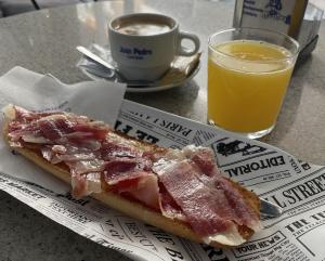 a sandwich and a cup of coffee and a glass of orange juice at Pensión Juan Pedro in Roquetas de Mar +19 photos