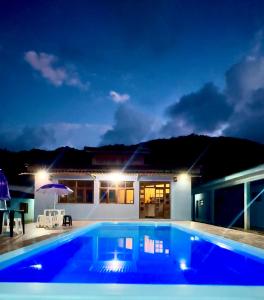 a swimming pool in front of a house at night at Pousada Almeida in Iguape