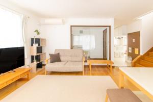 a living room with a chair and a television at つぐ屋札幌 in Sapporo