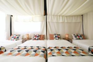 a room with two beds and a window at halfGlamping星音 B in Nakijin