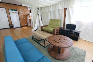 a living room with a blue couch and a table at halfGlamping星音 B in Nakijin