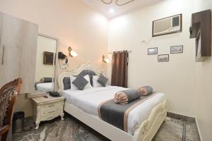 a bedroom with two beds and a mirror at Shree Ganesha Palace Near Kashi Vishwanath Temple in Varanasi