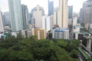 a city skyline with tall buildings and trees at The Mosaic Tower in Manila