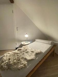 a bed with a furry blanket on it in a room at Fachwerk Juwel in Melsungen