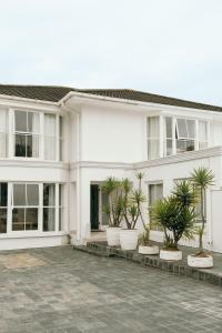 a white house with potted plants in front of it at Summer House B&B in Gqeberha