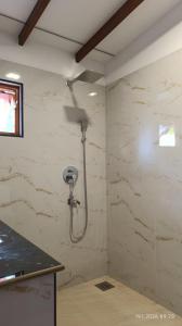 a bathroom with a shower in a wall at White Umbrella - Homestay in Beruwala