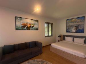 a bedroom with a bed and a couch at Villa Coastar 002 Hồ Tràm in Ho Tram