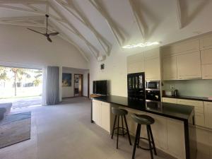 a kitchen with white cabinets and a black counter top at Villa Coastar 002 Hồ Tràm in Ho Tram +6 photos