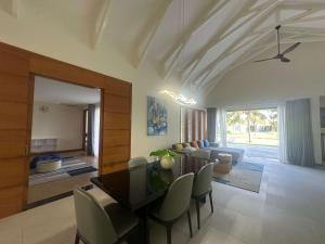 a living room with a table and chairs and a couch at Villa Coastar 002 Hồ Tràm in Ho Tram