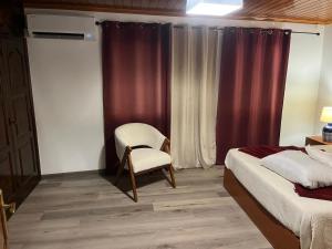 a bedroom with two beds and a chair and a window at Alvarenga House in Maia